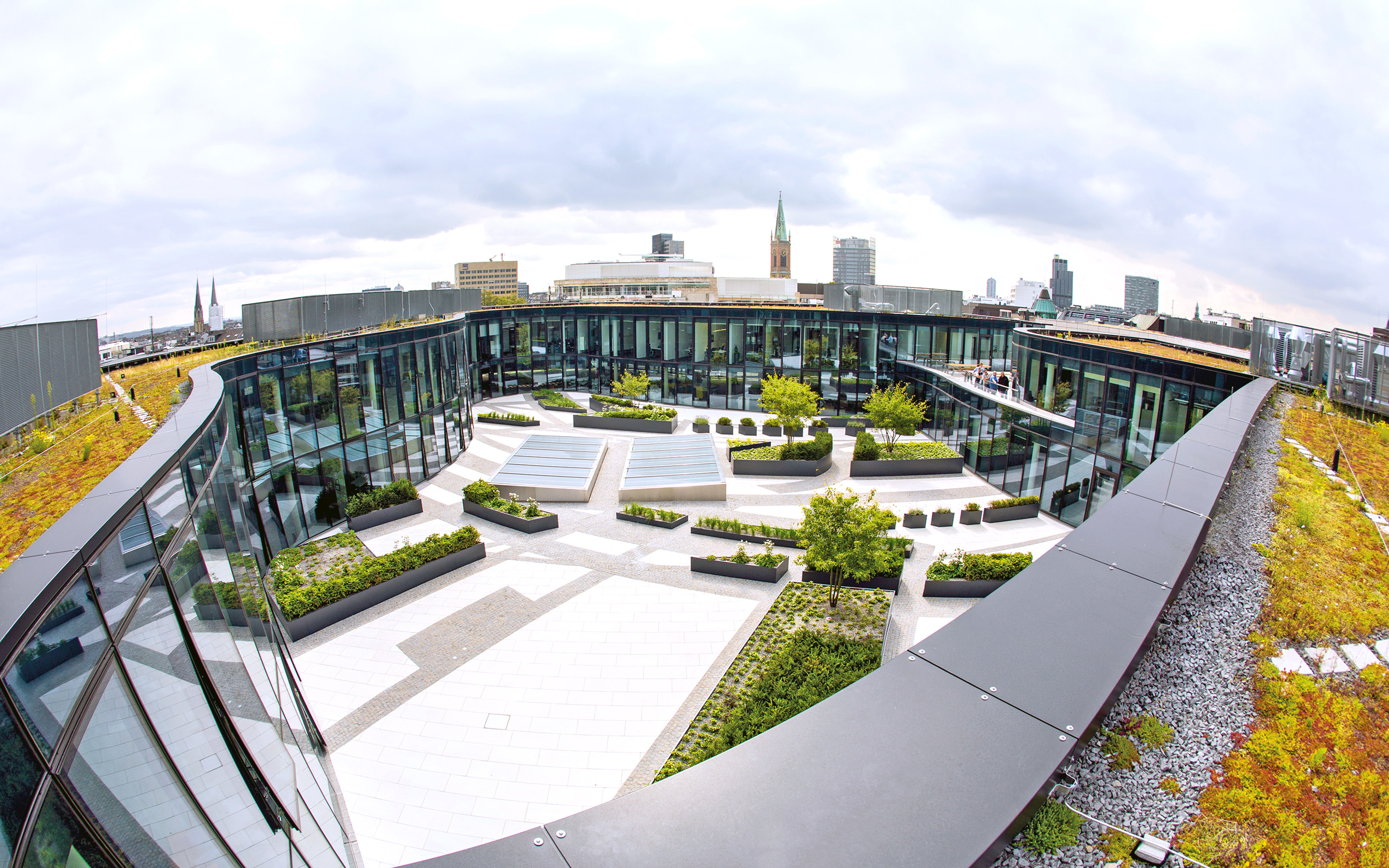 Sedum was applied on the roof surface, thus enhancing the sustainable concept. Green roofs planted with Sedum and view into the courtyard from above